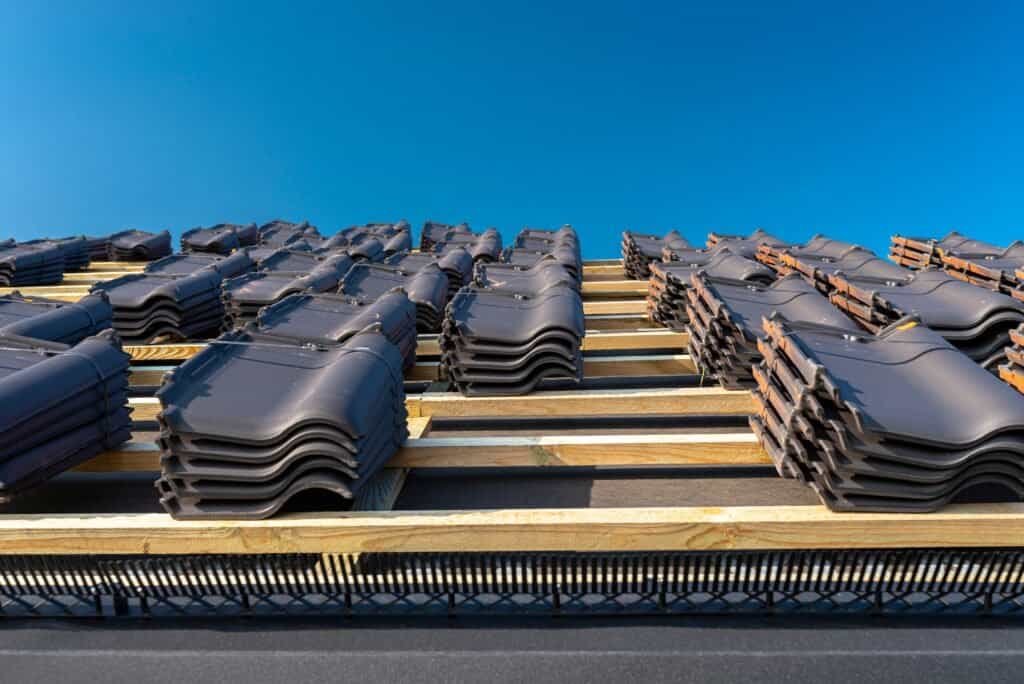 Stacks of roof tiles prepared for roofing projects, emphasizing roofing expertise.